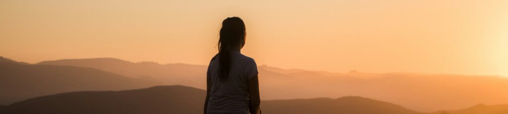 woman sitting on bench over viewing mountain