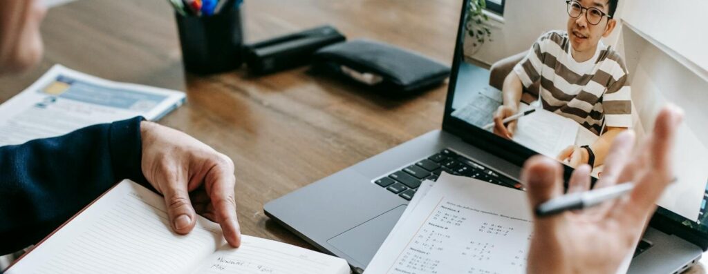 A professional conducting an online class through a video call with a student.