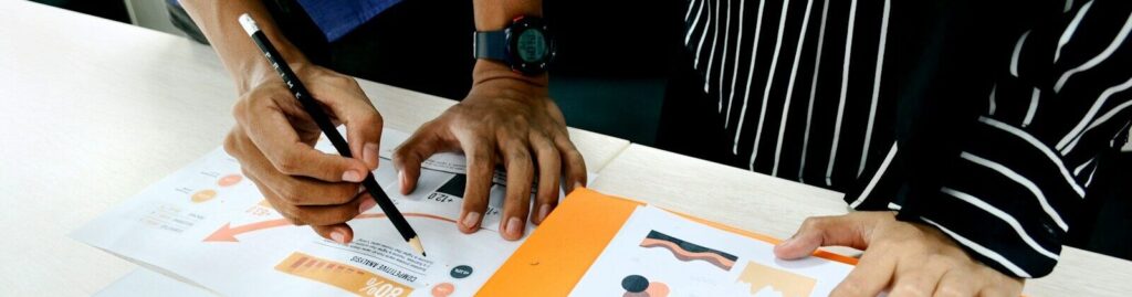 person in blue shirt writing on white paper