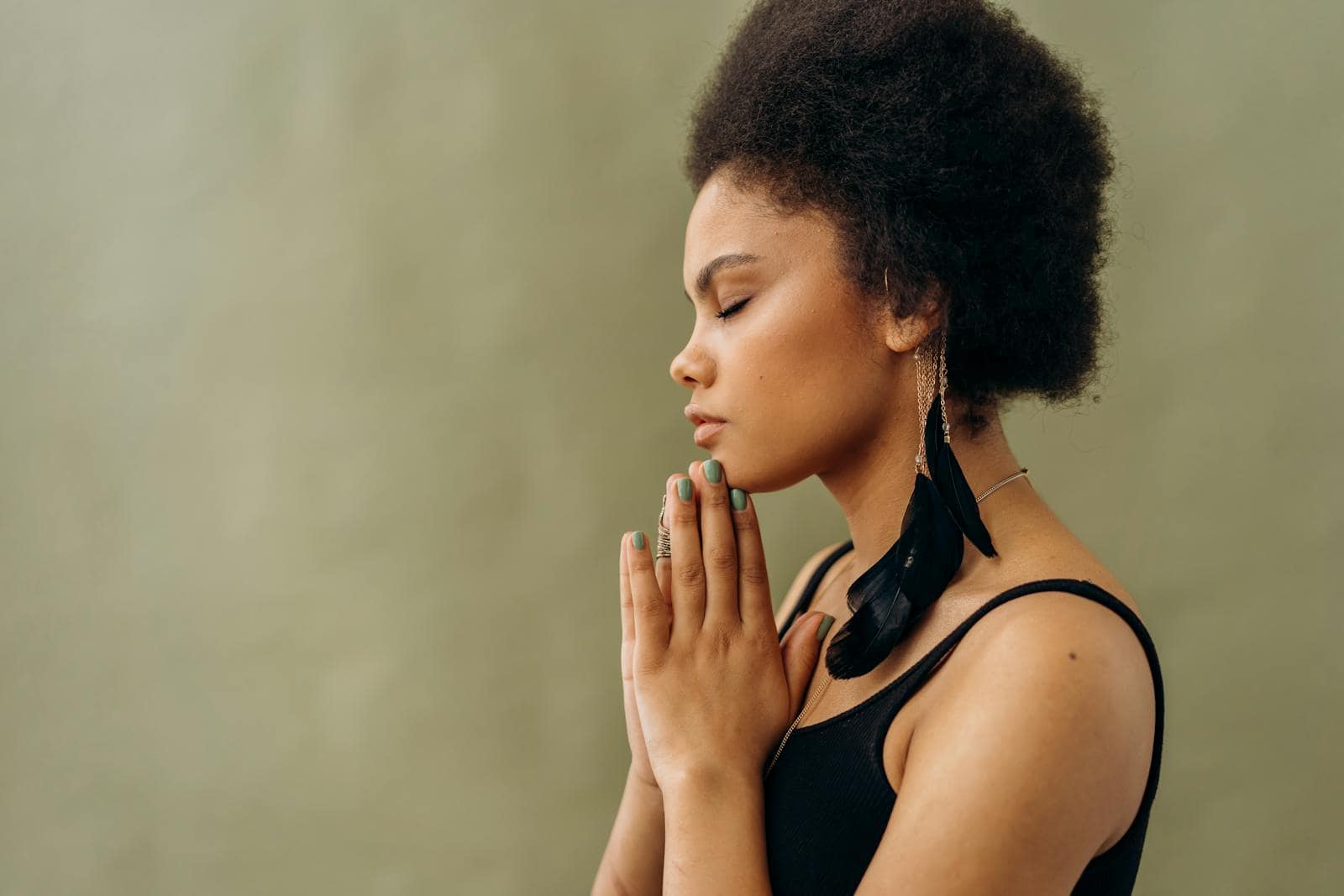 The Healing Power of Reiki, A young woman with afro hair practicing calming meditation indoors.