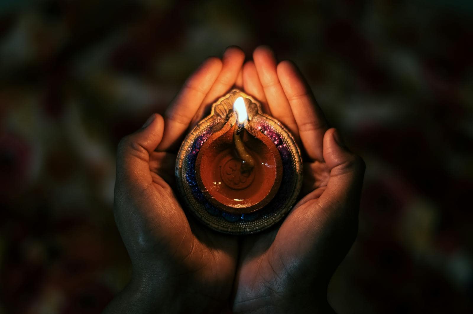 Energy, astrological symbols, zodiac, predictions, horoscope, Top view of crop anonymous person demonstrating small bright candle burning in dark evening in soft focus