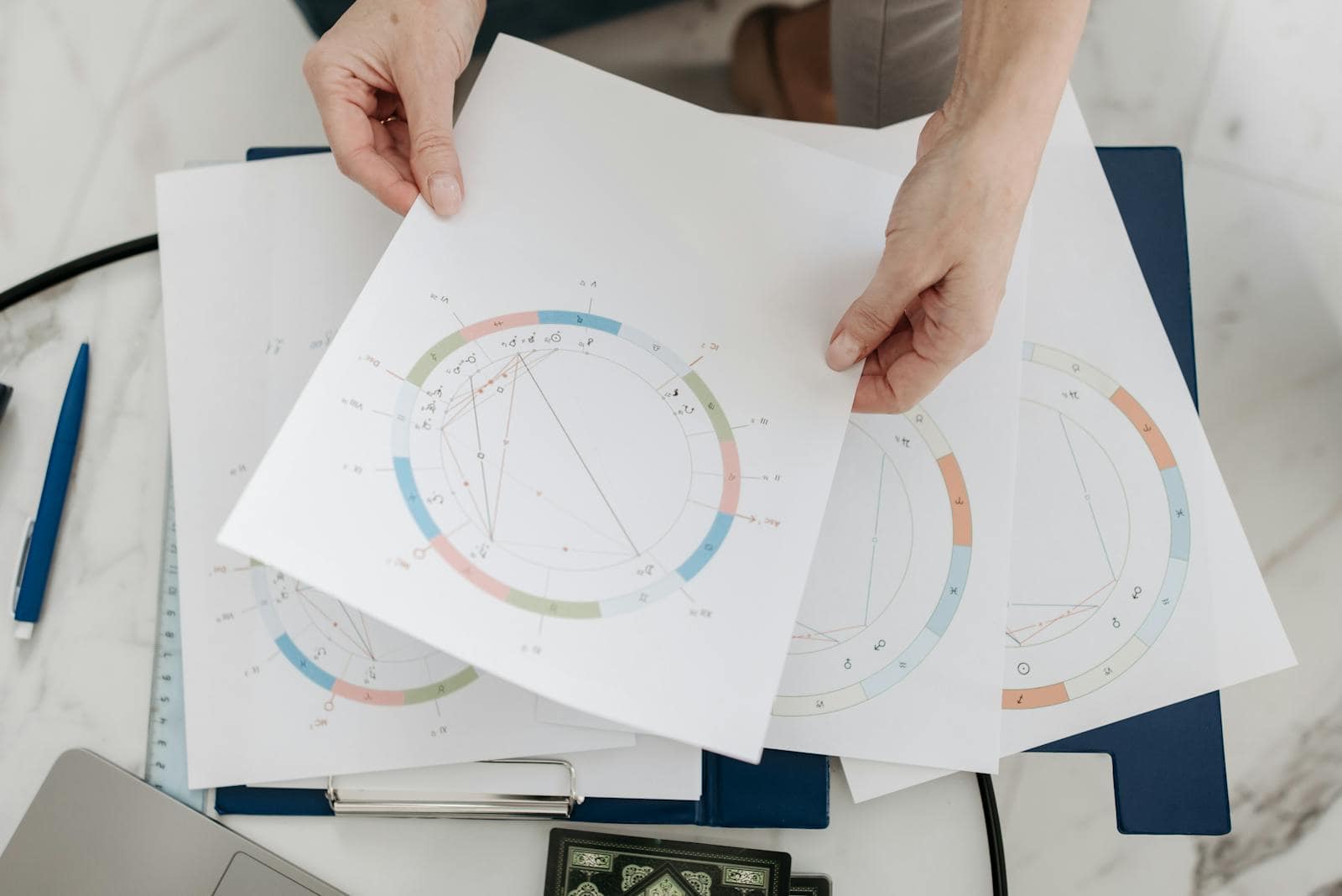 Hands holding astrological charts and graphs, symbolizing horoscopes and fortune-telling. Unlocking Your Destiny: Janmakshar Matching