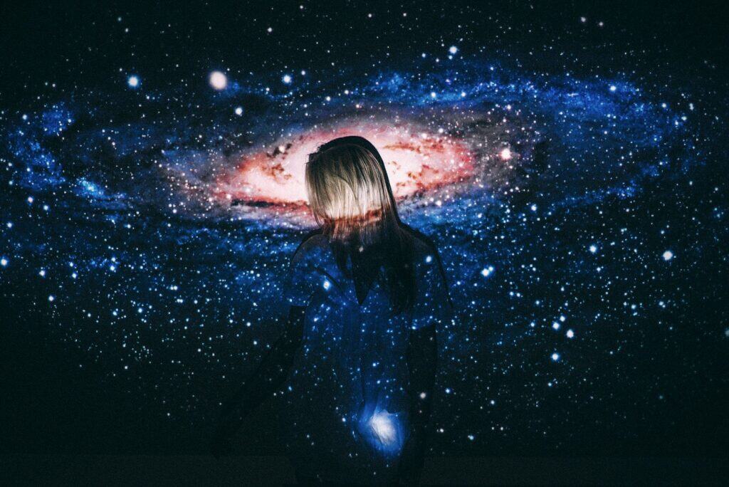 woman in black leather jacket looking at stars - cosmic archetype
