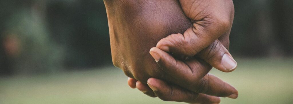 A close-up view of a couple holding hands, symbolizing love and togetherness.