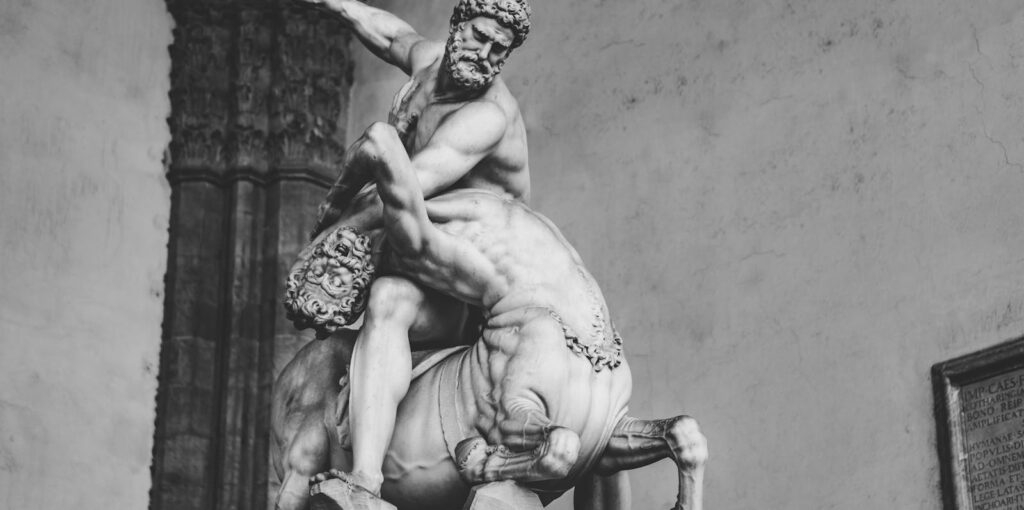Black and white photo of a detailed marble sculpture of Hercules fighting a centaur in Tuscany, Italy. Chivron, Centaur, Astrology, Relationships, Life improvements, Horoscope