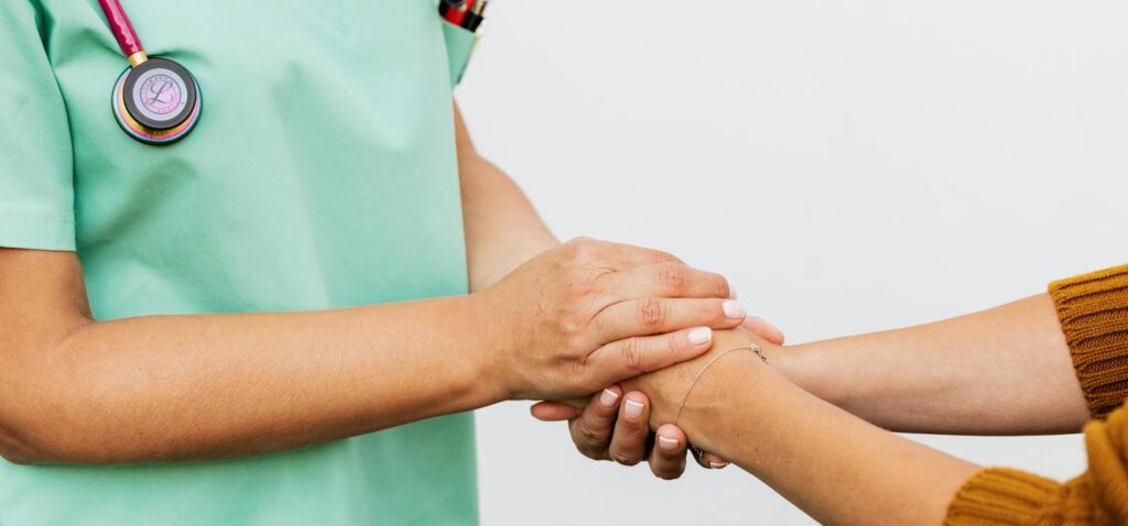 Close-up of a doctor holding a patient's hands, symbolizing trust and empathy in healthcare.