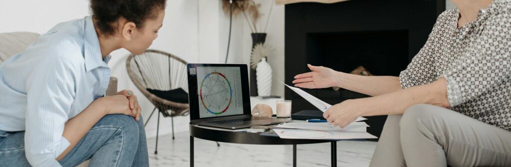 Astrologer and young woman discussing a natal chart on a laptop indoors. Natal Chart, Moon, Dreams