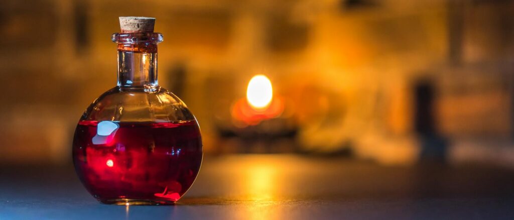 A mystical potion bottle glows warmly in candlelight against a rustic brick background. ALchemist, archetype, midhaven