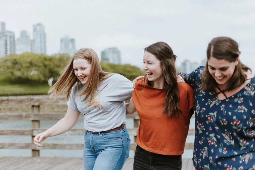 three women walking on brown wooden dock near high rise building during daytime, astrology, zodiaccompatibility, compositechart, relationshipastrology, karmicrelationships