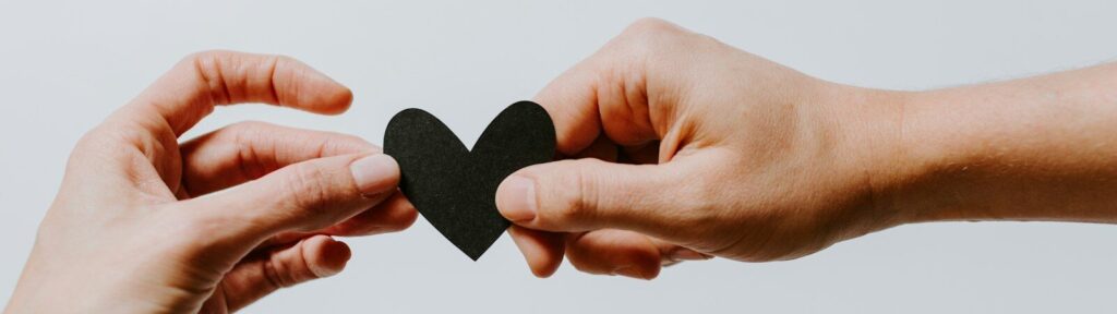 two person holding papercut heart