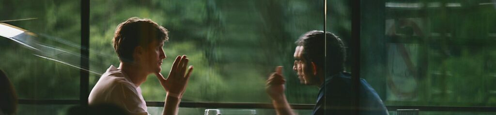 Two people talking at a table in a restaurant.