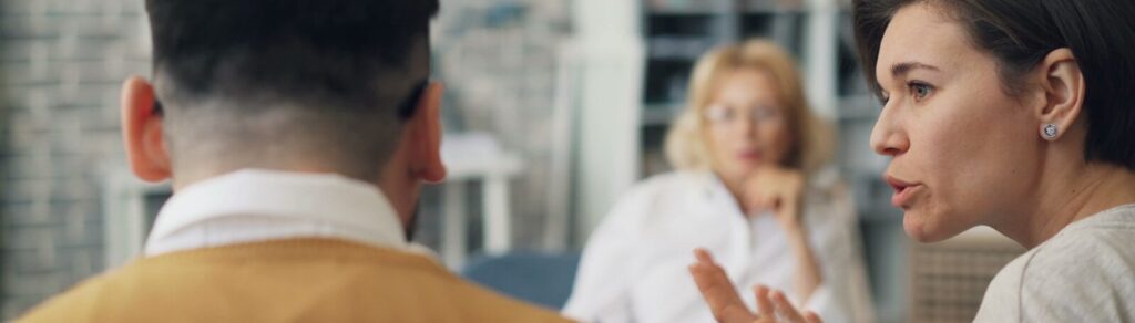 a woman talking to a man at a table