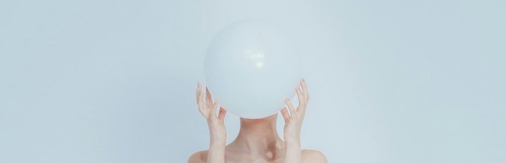 Woman holding a white balloon in front of her face.